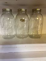 Front view of three Kerr Mason jars with lids