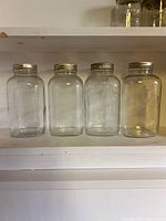 Front view of four Canadian Mason jars with lids