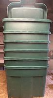 Stack of six green Rubbermaid totes with lids