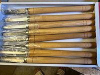 Box containing eight wood lathe chisels with wooden handles