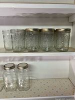Row of Bernardin 500 ml wide-mouth mason jars on shelf, mixed lids present