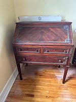 Front view of antique mahogany cylinder desk, roll-top closed
