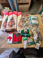 Overview of four tree boxes, deer packs, yarn, bows, garlands on workbench