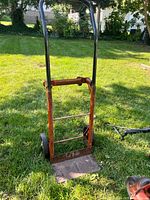 Front view of steel hand truck dolly standing on grass