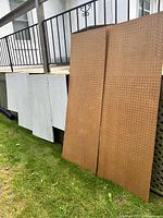 All pegboard pieces leaning against deck railing