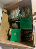 Cardboard box containing Bernardin Snap Lid boxes, additional packages and loose gold screw bands