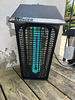 Bug zapper plugged in with blue UV bulb lit