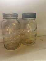 Two jars side by side showing brand embossing and lids