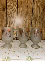 Three frosted footed mugs showing deer sunset side