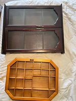 Light and dark wood display shelves laid flat showing compartments and glass doors