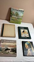 Top view of five hardcover art books including The Impressionists, Art Treasures of the Louvre, Norman Rockwell Illustrator, Winslow Homer, Vermeer