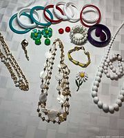 Overview of lot showing bangles, necklaces, bracelets, pins and earrings