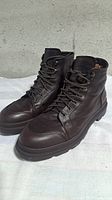 Pair of dark brown leather Brunello Cucinelli ankle boots angled side view