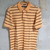 Front view of orange, white and black striped Givenchy polo shirt
