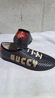 Side view showing gold GUCCY lettering, polka dots, red heel with bee embroidery