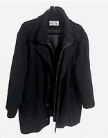 Front view of black wool overcoat on hanger showing button front, zipper, collar and pockets