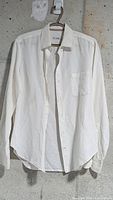 Front view of white Loro Piana linen shirt on hanger