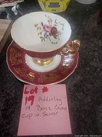 Cup on saucer showing floral interior and gold handle