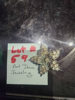 Brooch on table with lot note