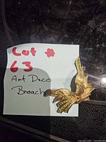 Front view of gold-tone brooch with green rhinestones