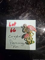 Brooch on note identifying it as crystal flamingo pin