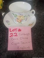 Teacup on saucer with note showing lot information