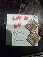 Front view of rhinestone brooch on note