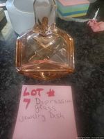 Pink depression glass covered jewelry dish standing upright