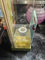 Front view of packaged reed diffuser showing one fragrance oil bottle and reed sticks