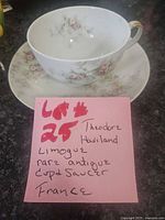 Cup on saucer with note identifying maker