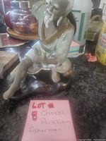 Front view of porcelain fisherman figurine