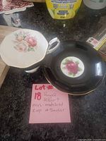 Teacup interior floral view beside black saucer