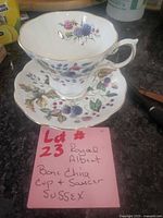 Teacup on saucer showing side pattern, gold trim, footed base