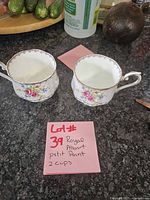 Two Royal Albert Petit Point teacups displayed on countertop