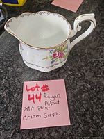 Side view of Royal Albert Petit Point creamer showing floral pattern and gold trim