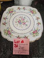 Top view of one dinner plate showing Petit Point floral pattern and scalloped square shape