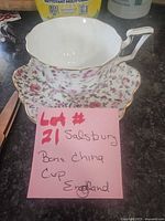 Teacup nested on saucer showing floral exterior and gilt edges