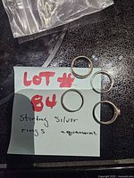 Four sterling silver rings on note indicating sterling silver and aquamarine