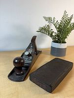 Hand plane and closed black wooden box on tabletop