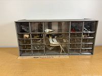 Front view of cabinet showing 23 drawers and mixed hardware contents