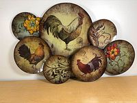 Front view showing all seven painted discs with rooster and floral designs