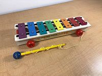 Top view of xylophone showing rainbow bars, wheels, mallet