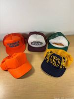 Group shot of all five caps showing fronts and mesh backs