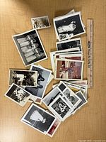 Pile of approximately forty mixed vintage snapshots beside 12-inch ruler for scale