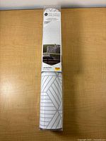 Front view of sealed RoomMates peel-and-stick wallpaper roll