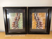 Front view of both black 12×16 frames with art inserts