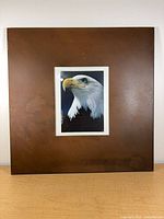 Front view of square metal frame displaying eagle photo for scale