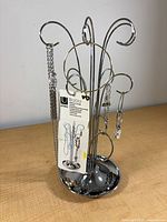 Front view of chrome Umbra Bijou jewelry stand with tag