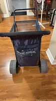Front view of Wonder Wheeler cart showing navy fabric bag, mesh sides, large wheels, padded handle