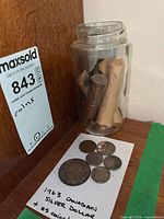 Jar with rolled coins and loose coins displayed beside label indicating contents